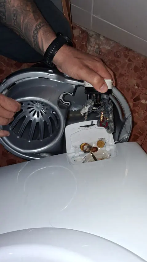 Detalle del filtro de desagüe obstruido por monedas y tornillos oxidados extraído en un domicilio de Barcelona.