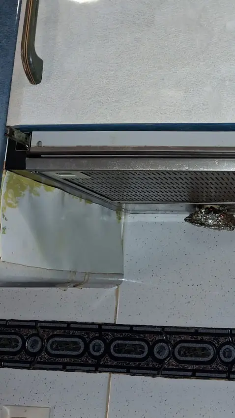 Inspección técnica del motor extractor antiguo con fatiga mecánica y restos de aceite.