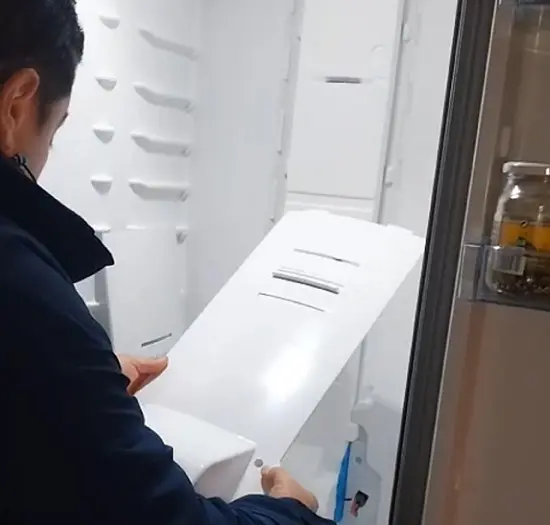 Especialista técnico comprobando enfriamiento de un frigorífico No-Frost.