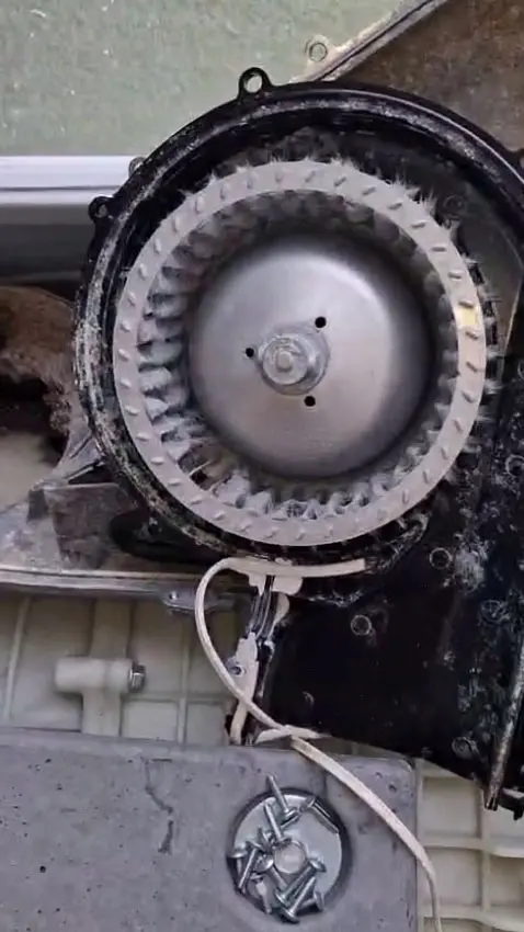 Limpieza de la turbina de ventilación de una secadora durante una reparación en Canet de Mar.