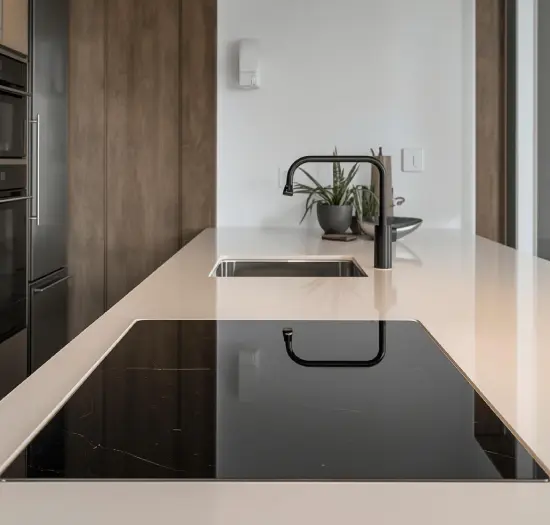 Placa vitrocerámica de inducción instalada sobre encimera de granito claro.